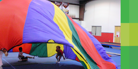 Kids playing with parachute at party at ELite Preschool